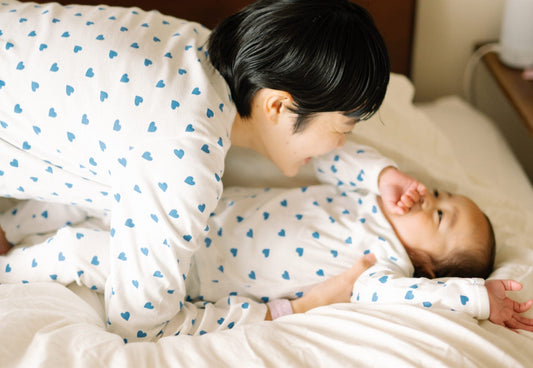 寝てる赤ちゃんを起こしてる写真