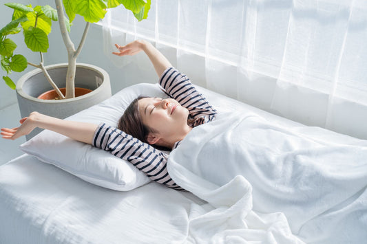 ベッドで背伸びをする女性の写真