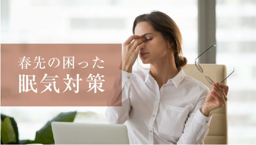 眉間を押さえる女性